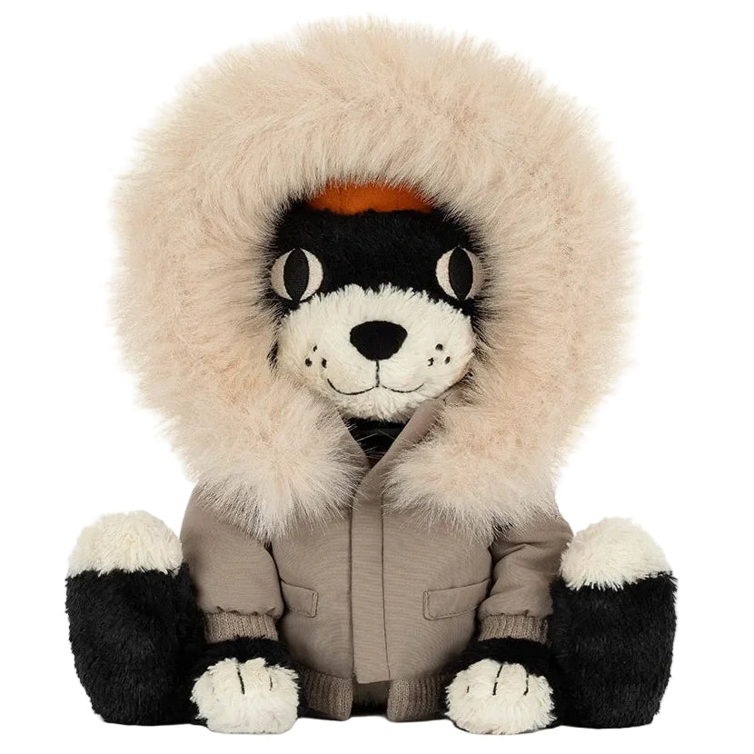 A black and white Jellycat Jack ‘Alpine’ plush cat wearing a beige parka with a faux-fur trimmed hood.