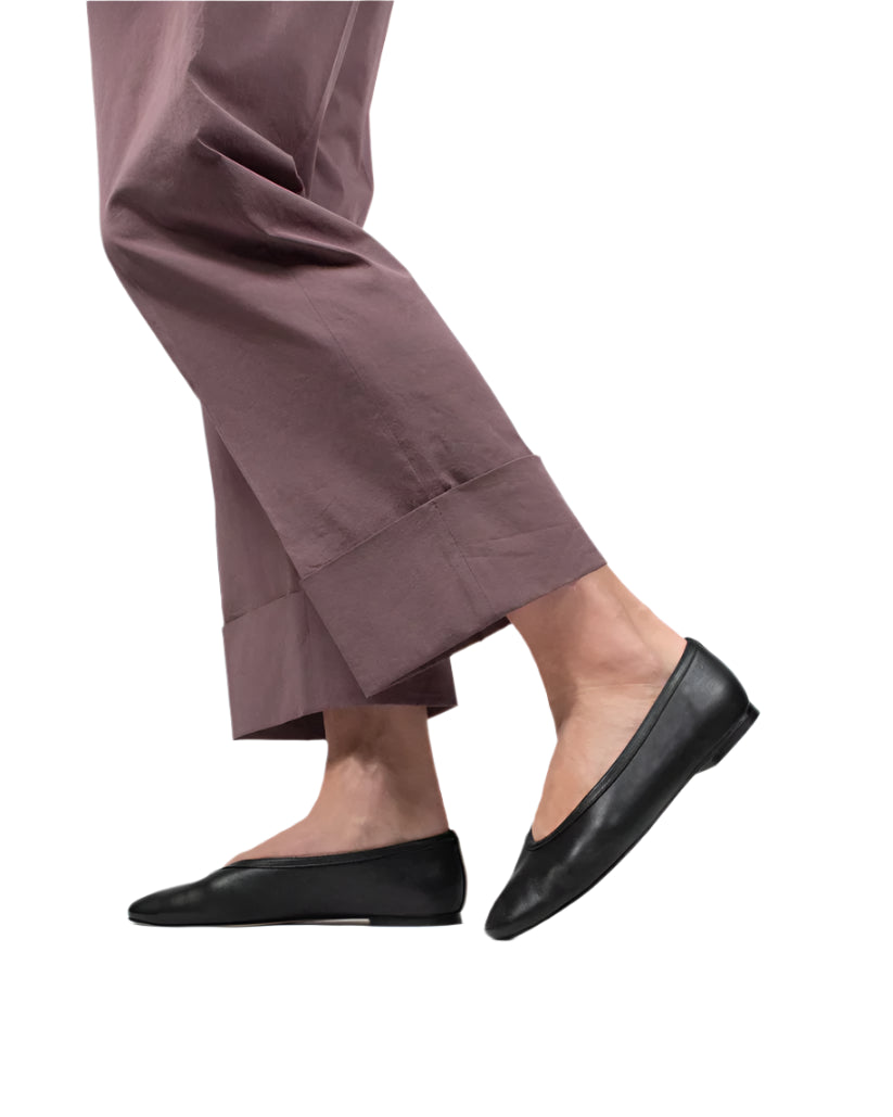 Model wears mauve cropped pants and Casa Isota Dafne Leather Flats in black Nappa leather, shown walking against a white background.