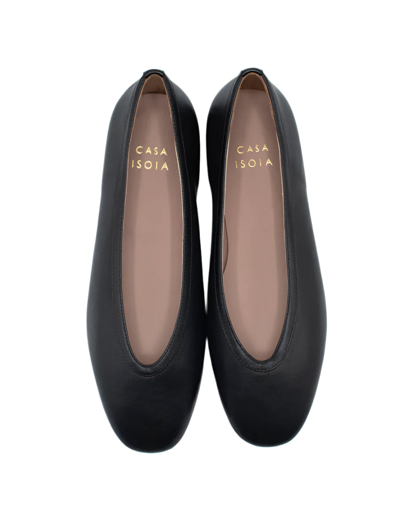 A pair of black Dafne Leather Flats by Casa Isota, crafted in supple Nappa leather with rounded toes. Tan insoles display gold "CASA ISOTA" lettering. Expertly made by Italian artisans for timeless elegance.