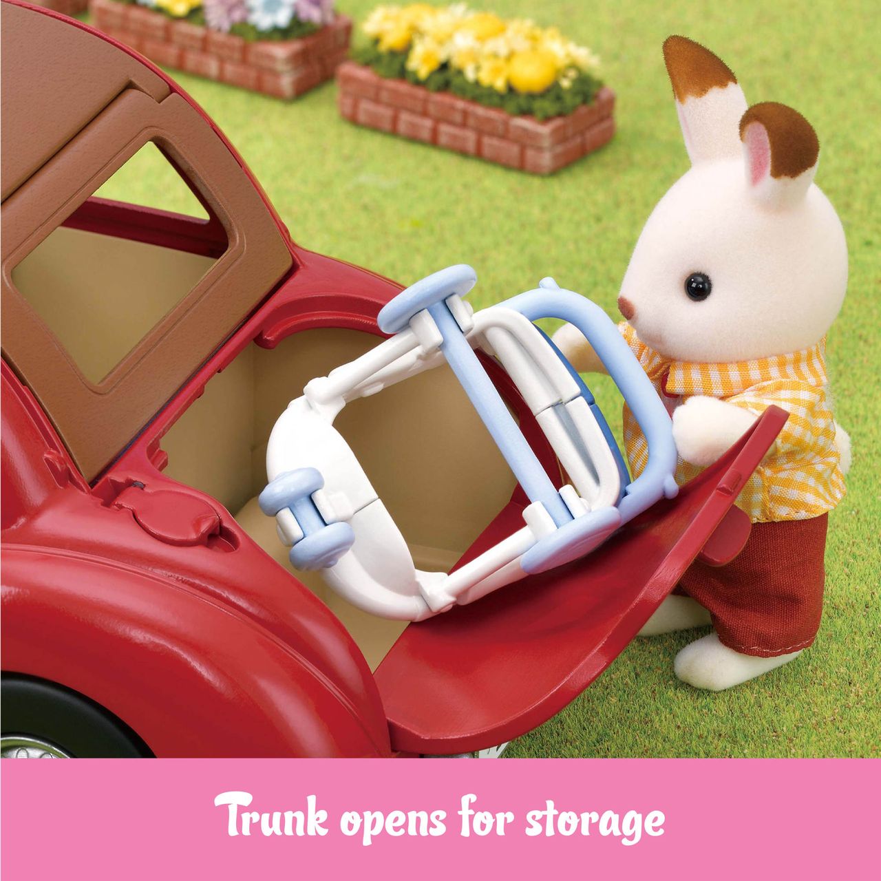 A toy rabbit figure places a folded stroller into the open trunk of the red Calico Critters Family Cruising Car, with a garden setting in the background. Text below reads, “Trunk opens for storage.” Perfect for adventures around Calico Village, the Family Cruising Car keeps all your essentials close at hand.
