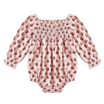 The Baby Girls' Adelaide Romper by Rylee & Cru features a light pink fabric with red floral print, smocked bodice, puffed sleeves with elastic wrists, and a gathered neckline.
