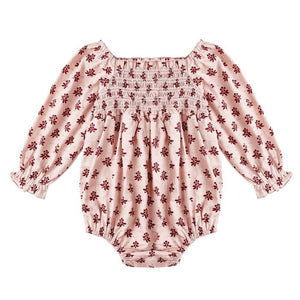 The Baby Girls' Adelaide Romper by Rylee & Cru features a light pink fabric with red floral print, smocked bodice, puffed sleeves with elastic wrists, and a gathered neckline.