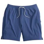 The Johnnie-O Hoppin Shorts feature an elastic waistband with a white drawstring and are crafted from soft rib-knit fabric with a subtle textured pattern in blue, displayed on a plain white background. These versatile shorts offer the perfect blend of comfort and style for any activity.