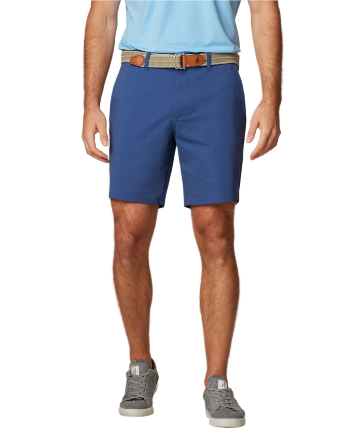 A man stands against a white background wearing a light blue shirt, gray sneakers, and Johnnie-O Jupiters Stretch Cotton Performance Shorts with a tan belt.