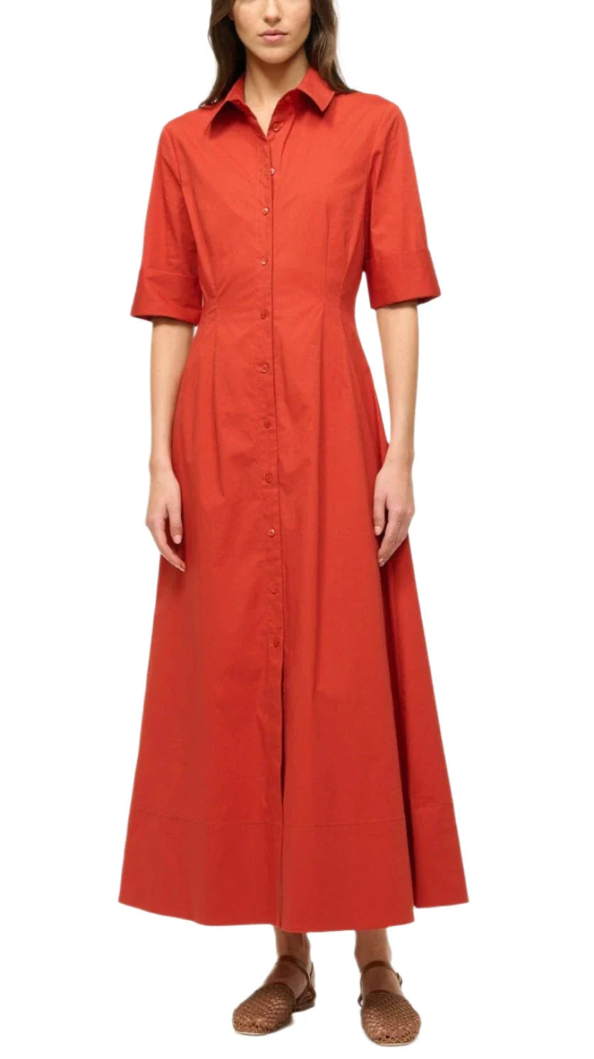 A person wearing the Staud Joan Maxi Dress, a red, button-down design with short sleeves in stretchy cotton poplin, paired with woven brown shoes.