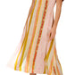 A woman models the Hunter Bell NYC Casey Dress, a versatile ankle-length piece with short sleeves and yellow, pink, and orange vertical stripes, styled with silver platform heels.