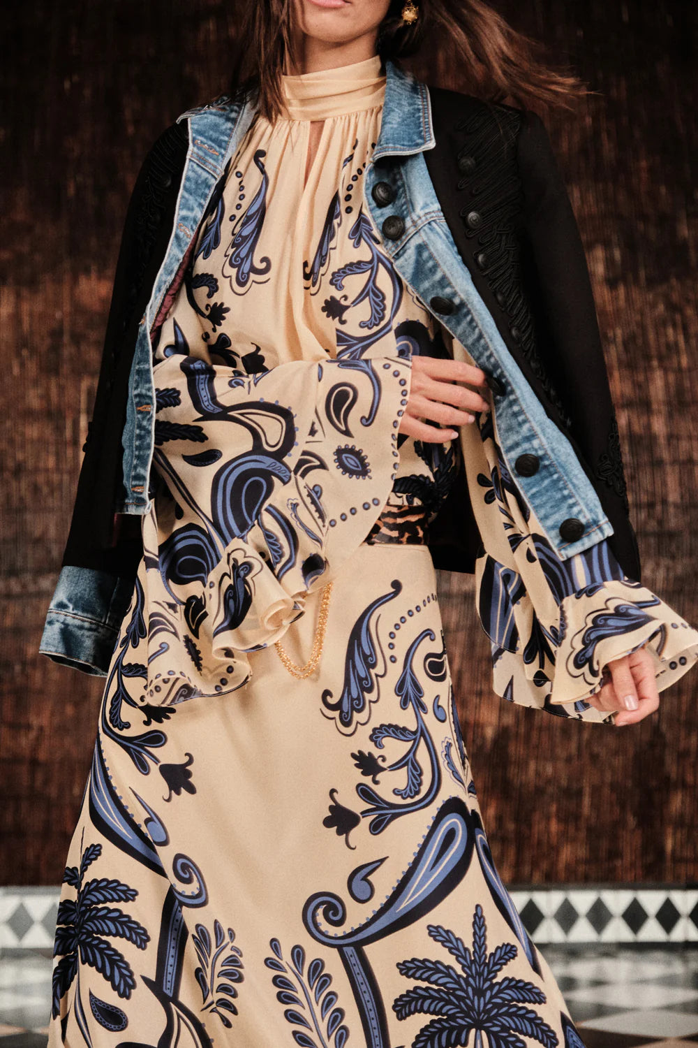 A person wearing the Johanna Ortiz Ritmo Sol Top stands in front of a brown textured background.