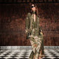 A woman in the Johanna Ortiz Eternity Begins Wrap Dress—an olive green, tropical JO print, silk crêpe de chine, ankle-length gown—wears sunglasses and sandals as she stands on a black-and-white checkered floor beneath a chandelier.