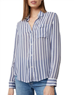 A woman wearing a blue and white striped Rails Josephine Top and blue jeans, midsection visible, standing against a plain background.