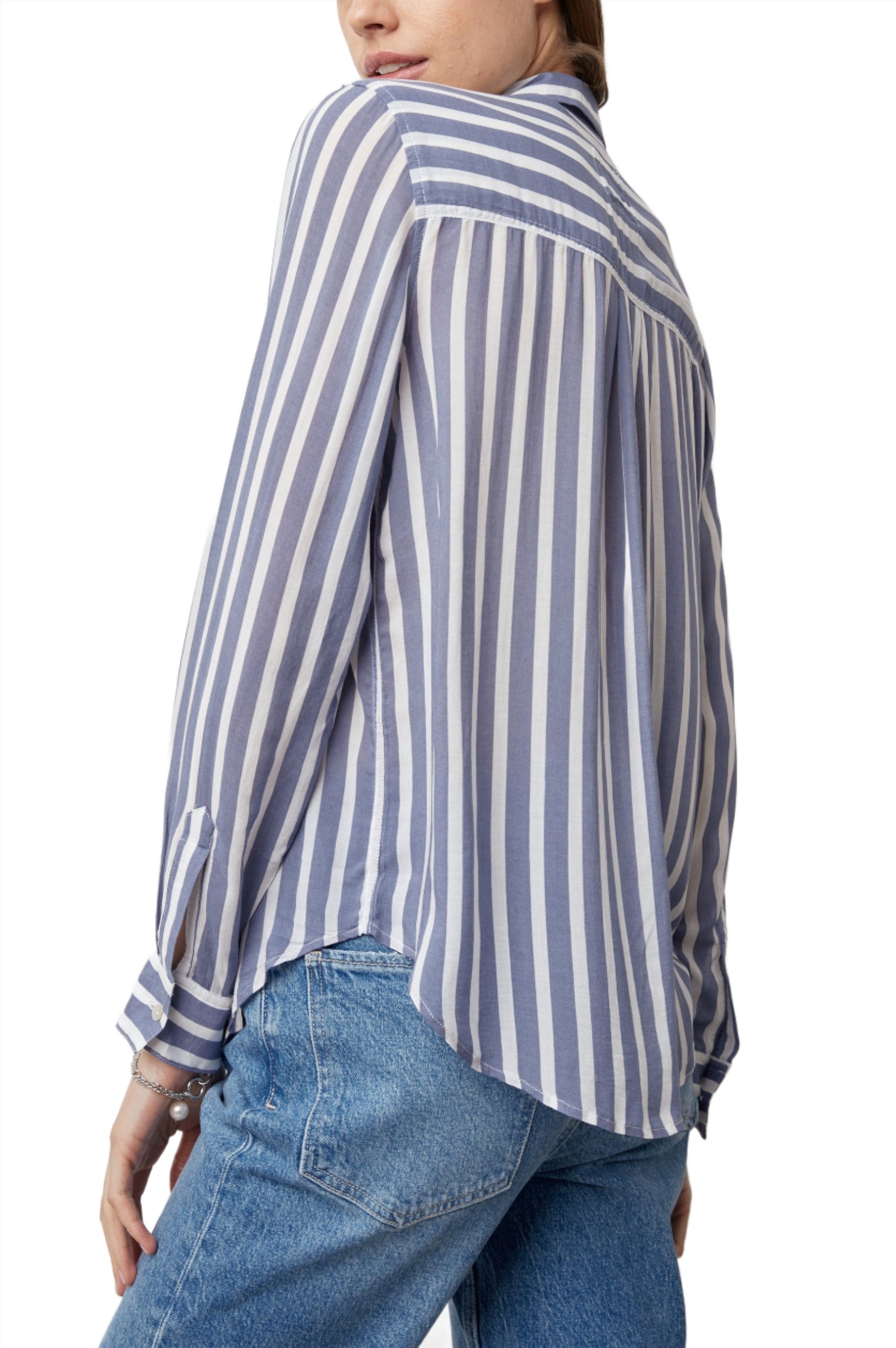 Woman in a blue and white striped button-down Rails Josephine Top and jeans viewed from the back, focusing on the detail of the shirt's design.