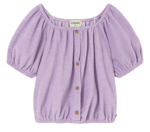 Cozmo Girls' Judy Terry Top in lavender—a short-sleeve blouse with a gathered neckline, button-down front, cropped silhouette, and elastic hem—displayed against a white background.