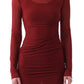A person stands against a plain background wearing Jason Wu's LS Double Layer Ruched Dress, featuring a fitted, long-sleeve burgundy design.