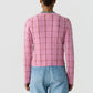 Person wearing the Jane Checker Cardigan by Guest in Residence in pink and light blue jeans, shown from the back against a plain white background.