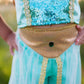 A child dressed in the Great Pretenders Jasmine Princess Set, a premium blue and gold sequined pant costume, stands outdoors with hands on hips; the photo highlights the torso and waist area.