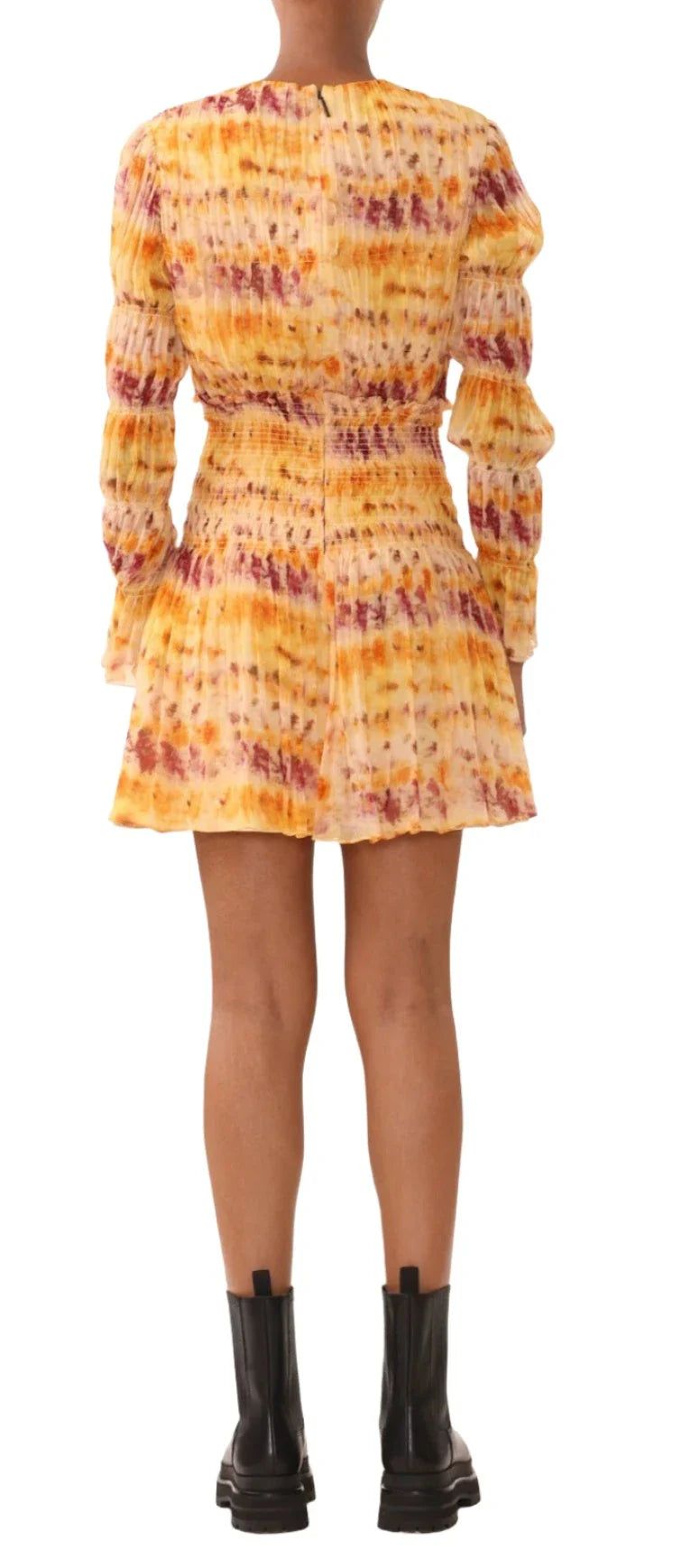 A person wearing the Jason Wu Printed Silk Crinkle Chiffon Dress, a long-sleeve, ombre floral outfit in shades of yellow, orange, and purple, paired with black ankle boots, is seen from the back.