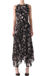 Person wearing a sleeveless, black Jason Wu Collection Pleated Chiffon Dress with a floral pattern and ruffled details, paired with black open-toe shoes.