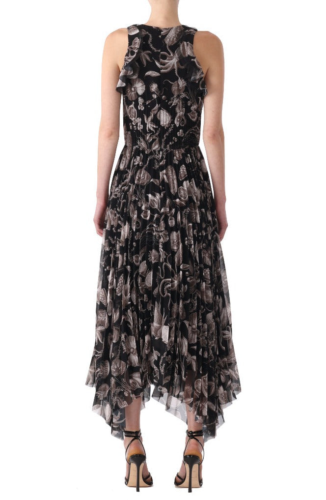 A person is standing facing away, wearing a sleeveless, ankle-length Jason Wu Collection Pleated Chiffon Dress with a white floral pattern and high-heeled sandals.