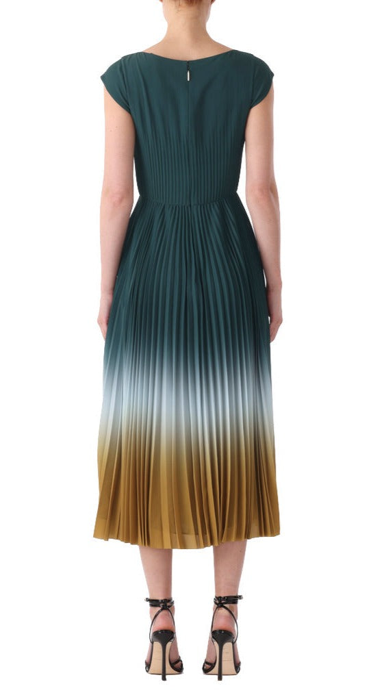 Back view of a woman wearing a Jason Wu Collection Dip Dye Marocaine Crepe Pleated Dress, featuring a dip dye color gradient from dark green at the top to mustard yellow at the bottom, paired with black high-heeled sandals.