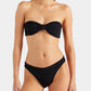 A woman wearing the Hunza G Jean Bikini, featuring black crinkle fabric, stands against a plain light background.