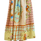 Woman wearing a white ruffled top and the Tatum Skirt by Hunter Bell NYC, a long midi skirt with pastel floral and geometric Gasparilla Gardens print, paired with strappy sandals.