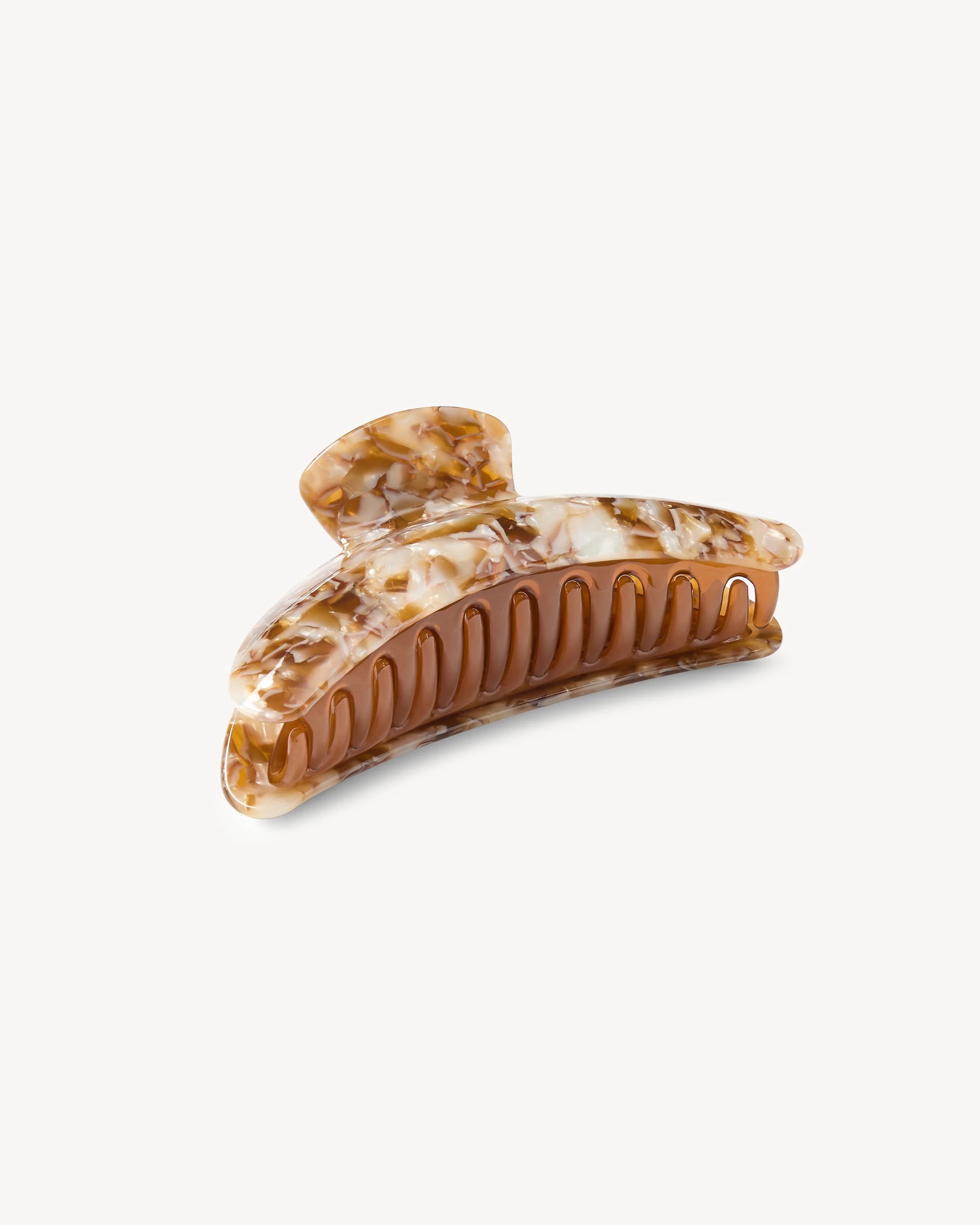 The Machete Jumbo Heirloom Claw, crafted from premium Italian acetate and featuring a brown and cream marbled design with curved teeth, is pictured against a plain white background.