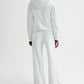 A person wearing the TWP Hoodie in light gray french terry with matching wide-leg pants stands with their back to the camera against a plain white background.
