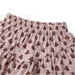 Close-up of the Girls' Tiered Mini Skirt by Rylee & Cru, featuring an elastic waistband, built-in shorts, and a small brown floral pattern on pink fabric.