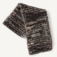 Folded chunky knit Kiva Scarf featuring a multi-colored pattern of brown, black, and cream yarn.