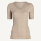 The Kallmeyer Pika Short Sleeve V-Neck is a beige ribbed pointelle knit top featuring short sleeves and a deep V neckline, made in Italy and shown against a plain white background.
