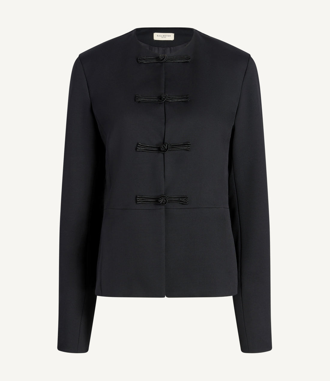 The Tilda Jacket by Kallmeyer is a black Grampians Twill long-sleeve style with a collarless neckline and four decorative knotted fastenings down the front, featuring a chic peplum silhouette for added elegance.