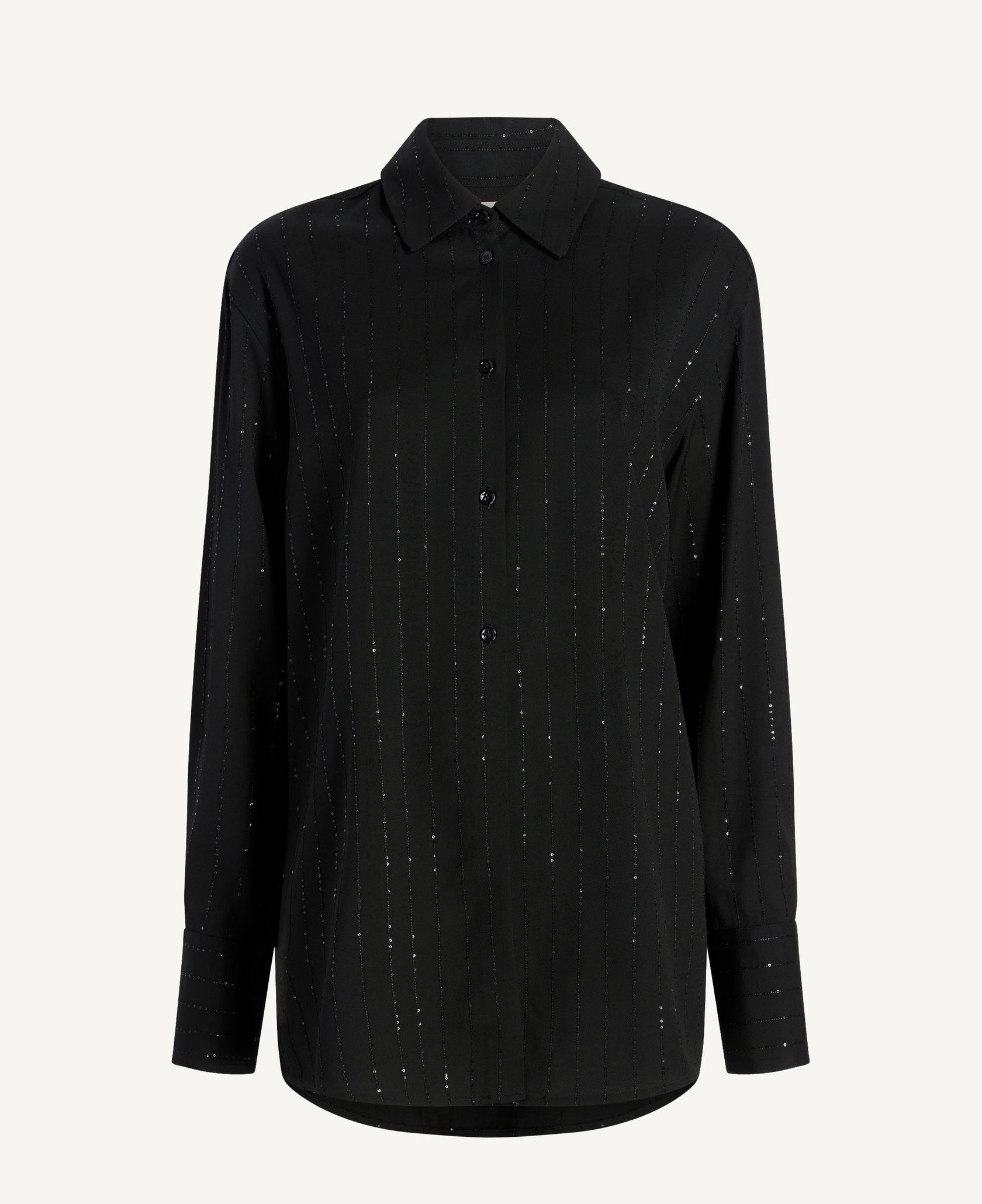 The Mollie Button Down by Kallmeyer is a long-sleeved oversized black shirt featuring a collar and subtle vertical dotted pattern, shown against a plain white background to highlight its relaxed fit.