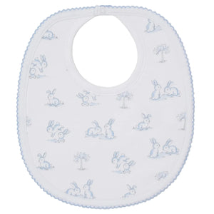 The Kissy Kissy Springtime Bunny Fun Bib is a soft white Pima cotton baby bib with light blue trim, featuring a playful print of blue and gray bunnies and tiny trees.