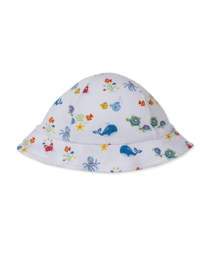 The Ocean Antics Sunhat by Kissy Kissy is a white bucket hat with a wide brim, made from soft Pima cotton and adorned with a vibrant ocean-inspired print featuring whales, turtles, crabs, octopuses, and starfish—making it the perfect baby sunhat for sunny days.