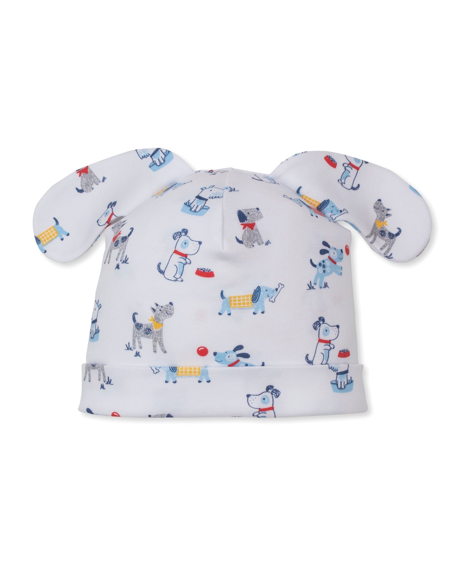 The Puppy Patch Novelty Hat by Kissy Kissy is a white baby hat made from soft Pima cotton, featuring floppy ears and a playful puppy patch print with cartoon dogs, bones, and bowls in blue, gray, red, and yellow.