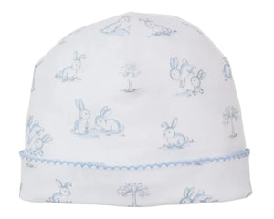 The Kissy Kissy Springtime Bunny Fun Hat is a white baby beanie made of soft Pima cotton, decorated with light blue bunny and tree prints, and finished with a scalloped blue trim.
