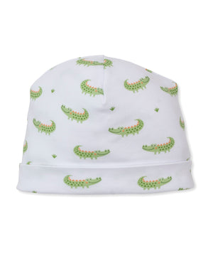 The Kissy Kissy Baby Boys’ Crocodile Camp Hat is crafted from soft Pima cotton and features a playful green cartoon alligator and grass patch print.