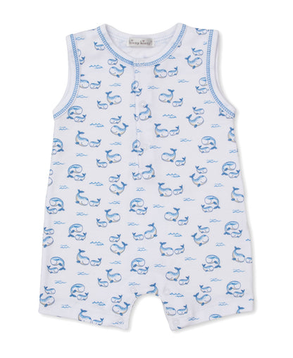 Kissy Kissy Baby Boys’ Whale Pods Sleeveless Playsuit crafted from soft Pima cotton features a charming blue whale and wave pattern on white fabric, with front buttons and blue trim around the arm and neck openings—an adorable choice for summertime adventures.