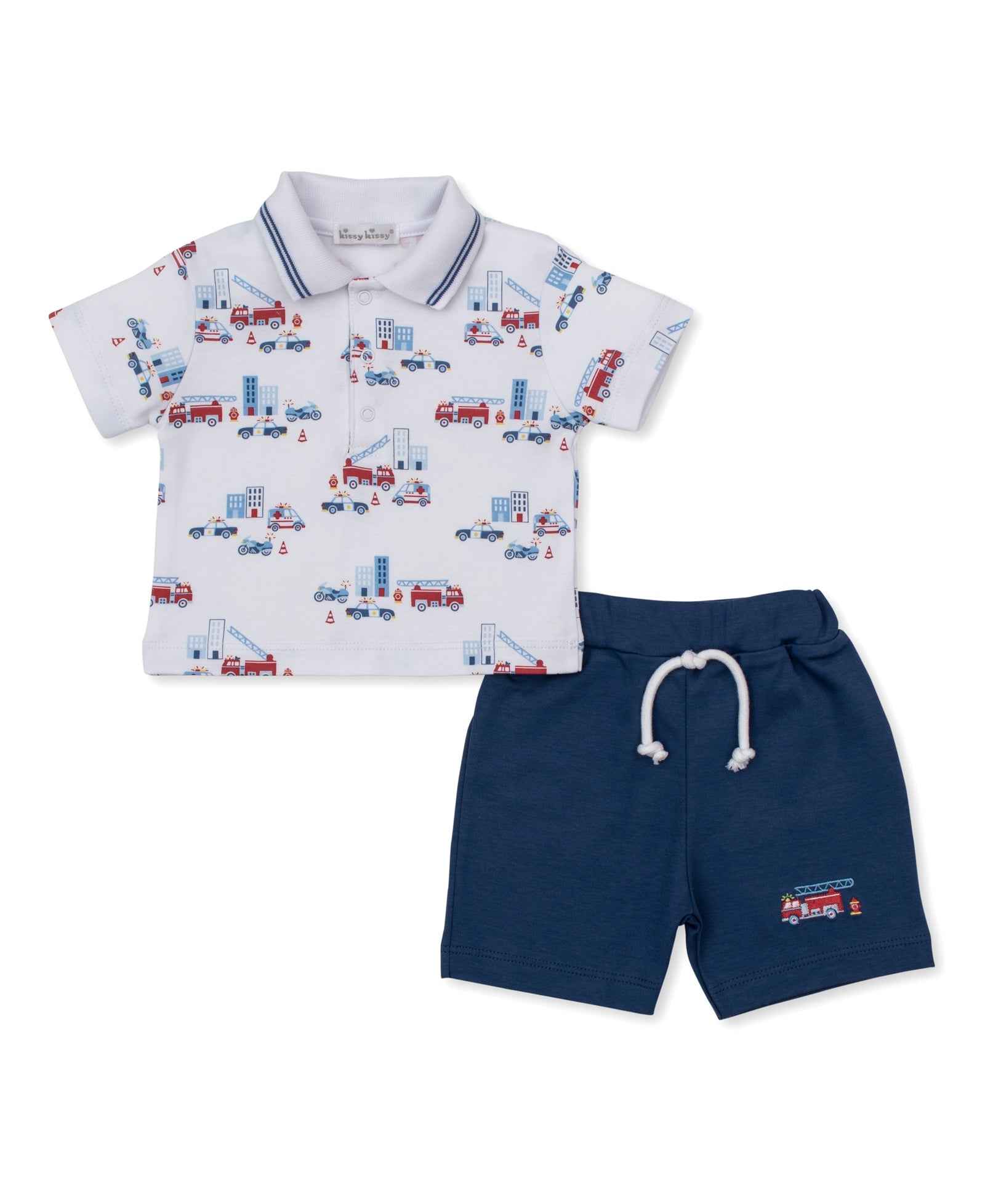 The Kissy Kissy Baby Boys’ and Boys’ Rescue Raid Bermuda Set features a short-sleeve polo shirt adorned with an allover rescue raid print of fire trucks and city scenes, paired with navy blue drawstring shorts finished with a small firetruck embellishment on the left leg.