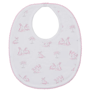 The Kissy Kissy Springtime Bunny Fun Bib features adorable rabbits and trees with a pink trim, crafted from soft Pima cotton for comfort and style.