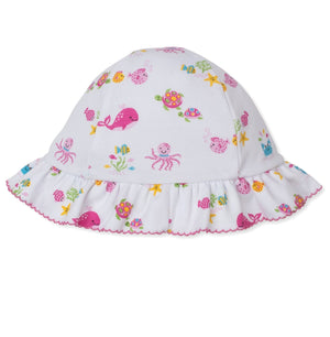 The Kissy Kissy Baby Girls’ Ocean Antics Printed Floppy Hat is made from soft Pima cotton and features a ruffled brim, adorned with a vibrant ocean print showcasing colorful sea creatures like whales, turtles, octopuses, and fish.