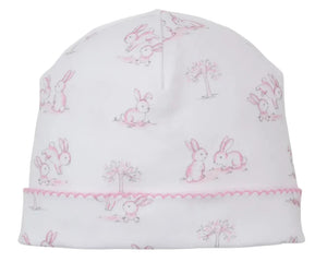 The Kissy Kissy Springtime Bunny Fun Hat is a white Pima cotton baby hat with pink embroidered trim, featuring a delightful light pink and gray bunny and tree print.