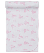 The Kissy Kissy Giraffe Grace Blanket is a white Pima cotton baby blanket featuring pink giraffe and girl illustrations, rolled at the top edge and finished with light pink stitched trim.