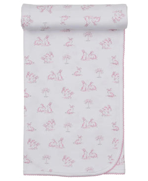 The Kissy Kissy Springtime Bunny Fun Blanket is a white Pima cotton baby blanket with pink edging and a repeating pattern of pink-outlined bunnies and small trees, shown partially rolled at the top.