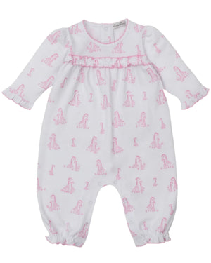 The Kissy Kissy Baby' Giraffe Grace Playsuit is a white long-sleeve Pima cotton playsuit with a pink giraffe print, ruffled cuffs, and snap buttons at the back and legs.