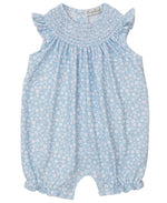 The Kissy Kissy Baby Girls' Fall in Bloom Smocked Sleeveless Playsuit features a white floral pattern, ruffled shoulders, smocked neckline, and elastic leg openings.