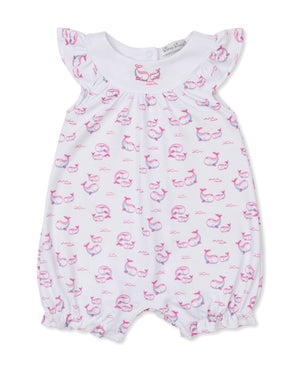 The Kissy Kissy Baby Girls' Whale Pods Playsuit, crafted from white Pima cotton and featuring flutter sleeves, a pink and blue whale pods print, and elastic leg openings, is displayed on a plain background.
