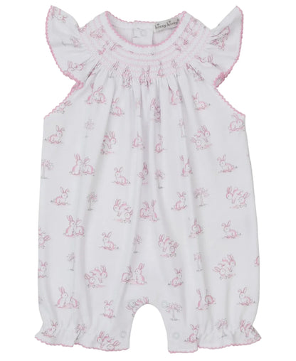 The Kissy Kissy Baby Girls' Springtime Bunny Fun Pink Short Smocked Playsuit features soft Pima cotton, a pink bunny print, ruffled sleeves, a smocked neckline, and delicate pink stitching.