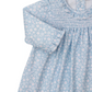 The Kissy Kissy Baby Girls' Fall in Bloom Printed Smocked Dress Set is a soft Pima cotton long-sleeve dress with white and pink floral print, smocked chest, ruffled collar, and button accents at the neckline.