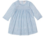 The Kissy Kissy Girls' Fall in Bloom Printed Smocked Dress features long sleeves, a white floral print on light blue, a gathered bodice, ruffled collar, elastic cuffs, and soft Pima cotton for toddler comfort.