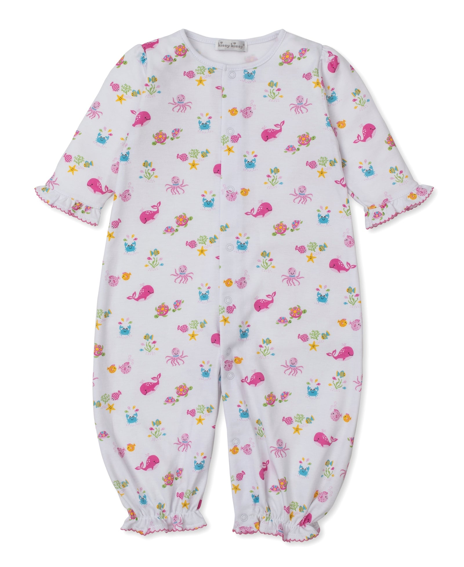 The Kissy Kissy Baby Ocean Antics Convertible Gown is a white long-sleeve baby romper made from soft Pima cotton. It features a playful pink ocean antics print with sea creatures and flowers, ruffled cuffs, and elasticized ankles. Shown here, the adorable converter gown is displayed flat on a plain background.